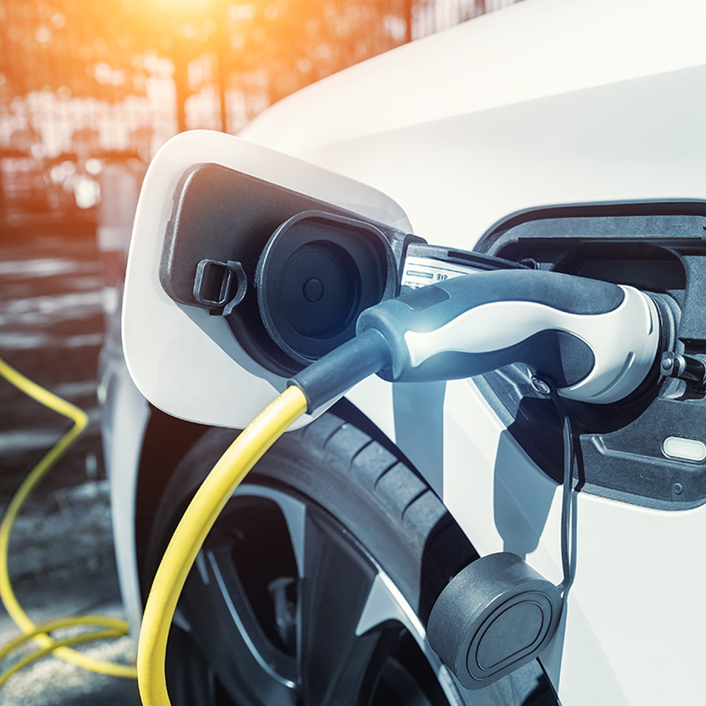 Electric vehicle charging with a yellow cable connected to a white EV - representing fast and reliable EV charging solutions available from Evergy in Thame.